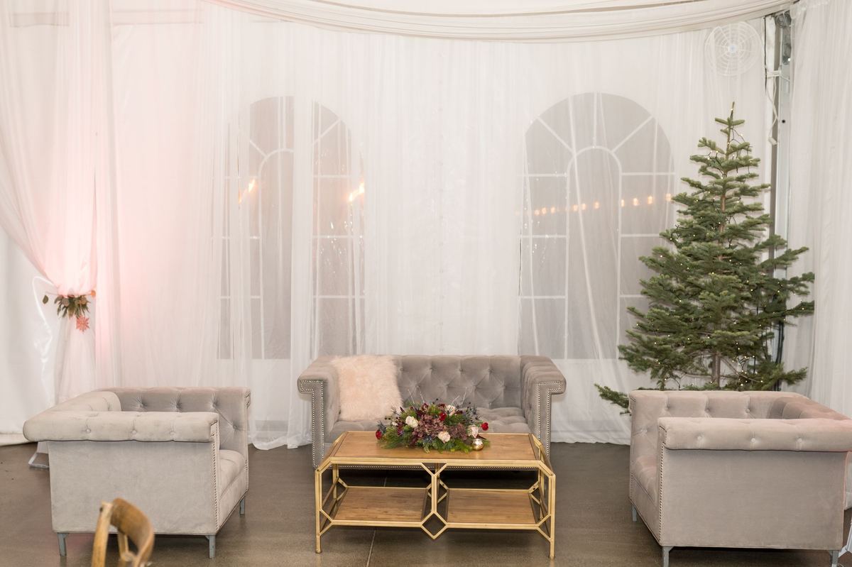 Holiday lounge setup with a Christmas tree and velvet sofas inside The Silos Event Center